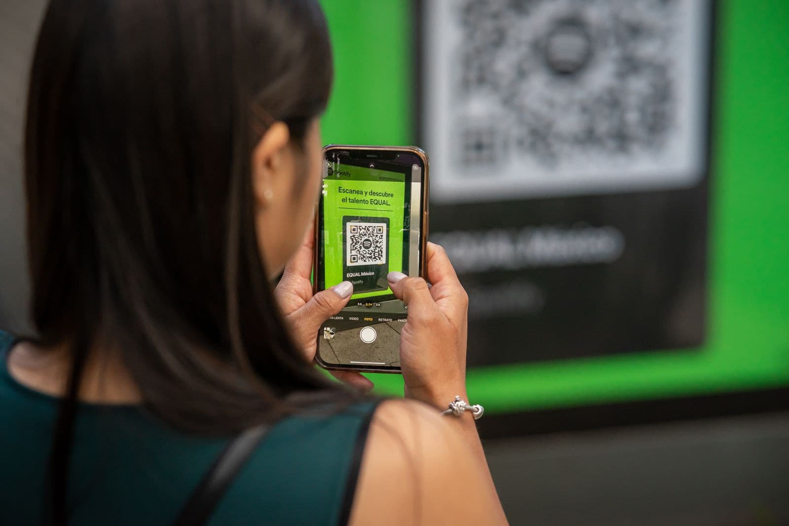 A woman scans a QR code with her phone to follow a shop, a simple tap to stay in the loop.