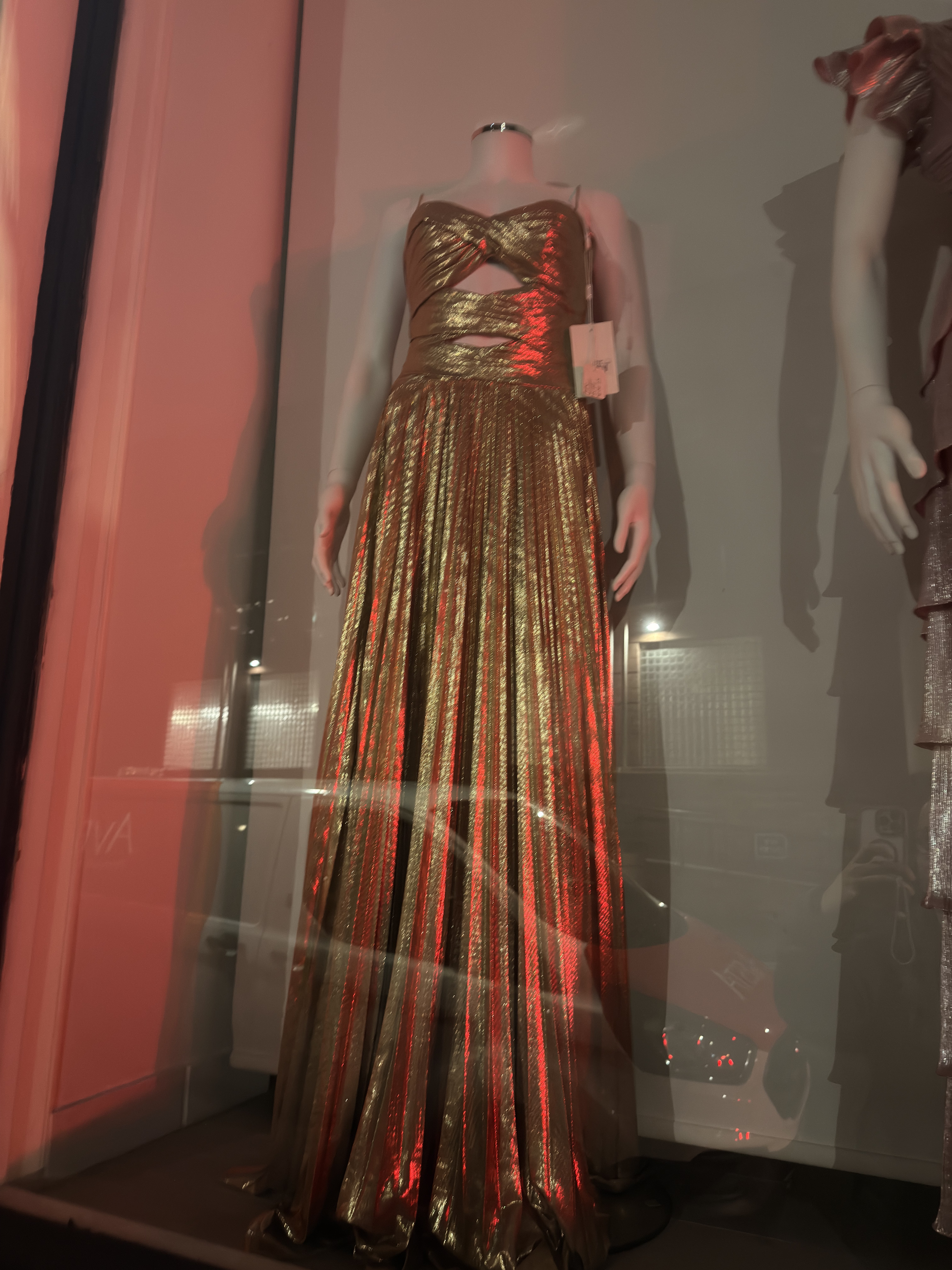 Gold pleated dress on a shop mannequin in a store display, the kind of product photo most independent retailers have available